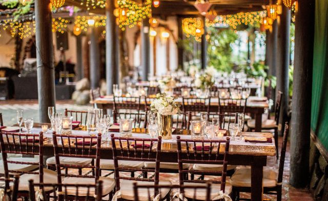 Charming outdoor dining setup with warm bistro lights and floral centerpieces.